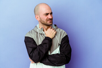 Young caucasian bald man isolated on purple background suffers pain in throat due a virus or...