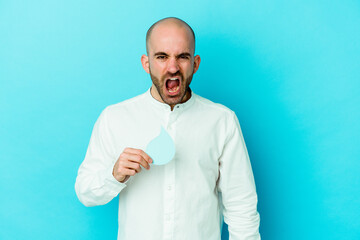 Young caucasian bald man celebrating world water day isolated on blue background screaming very angry and aggressive.