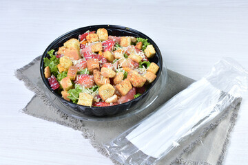 Rich very colorful vegetable salad, with croutons, strawberries, lettuce, Parmesan cheese and cherry tomato on white wooden background