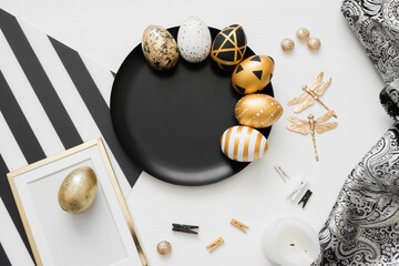 Happy Easter background with golden decorated eggs on black plate isolated on white background. Trendy flat lay easter. Card with copy space for text. Minimal easter concept.