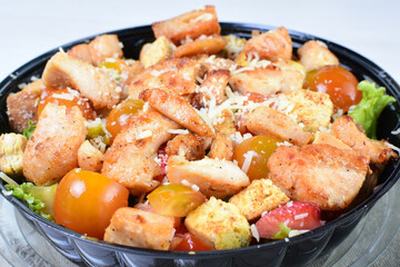 Rich very colorful vegetable salad, with croutons, strawberries, lettuce, Parmesan cheese and cherry tomato on white wooden background
