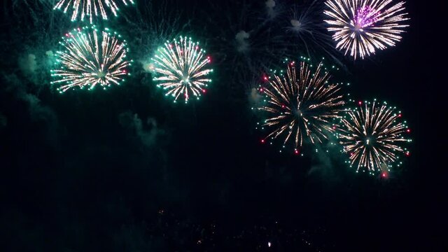 Colorful vibrant fireworks illuminate dark sky background