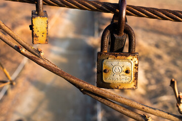 An old, rusty love lock displaying the words "Always Smile" hanging on steel wire from Haneul Sky Park in Seoul, South Korea. 