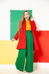 Happy fashionable woman in green pants in studio with white background