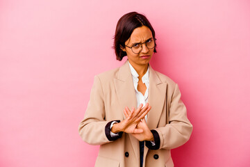 Young business mixed race woman isolated on pink background standing with outstretched hand showing stop sign, preventing you.