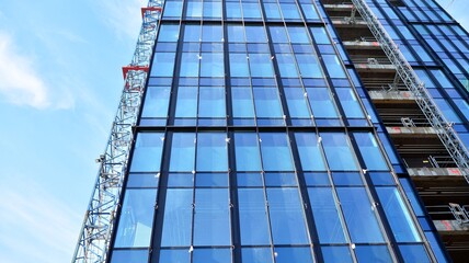 View of a skyscraper under construction. Modern architecture background. Building a high-rise building,  the concept of real estate construction. 