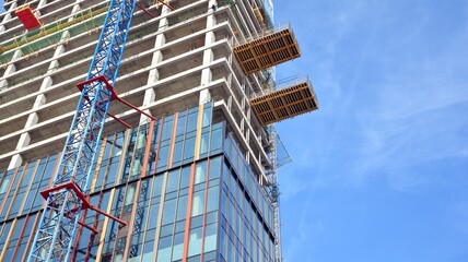 Fototapeta premium View of a skyscraper under construction. Modern architecture background. Building a high-rise building, the concept of real estate construction. 