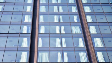 The glass facade of a skyscraper. Modern office building and sky reflection.