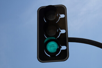 Traffic light with a blue sky. Green light to the traffic.