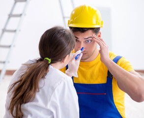 Doctor helping injured worker at construction site