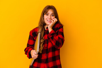 Young caucasian woman holding a laptop isolated biting fingernails, nervous and very anxious.