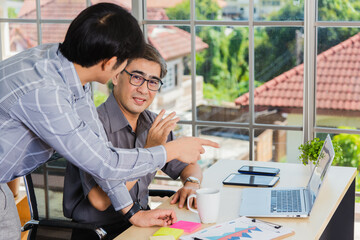 Asian senior and young business man working online on a modern laptop computer he looking the...