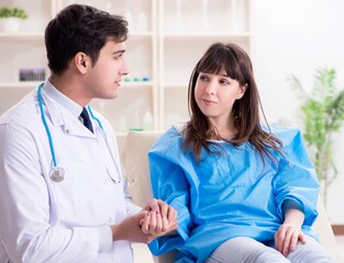 Male doctor checking up female patient in hospital