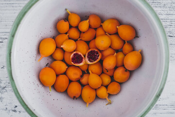 bluecrown passion fruits in fruit bowl with one cut in half to show the seeds inside, simple food ingredients concept