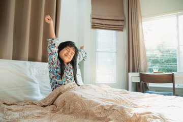 Asian child girl enjoys sunny morning. Good time at home. Kid wakes up from sleep. child girl wakes...
