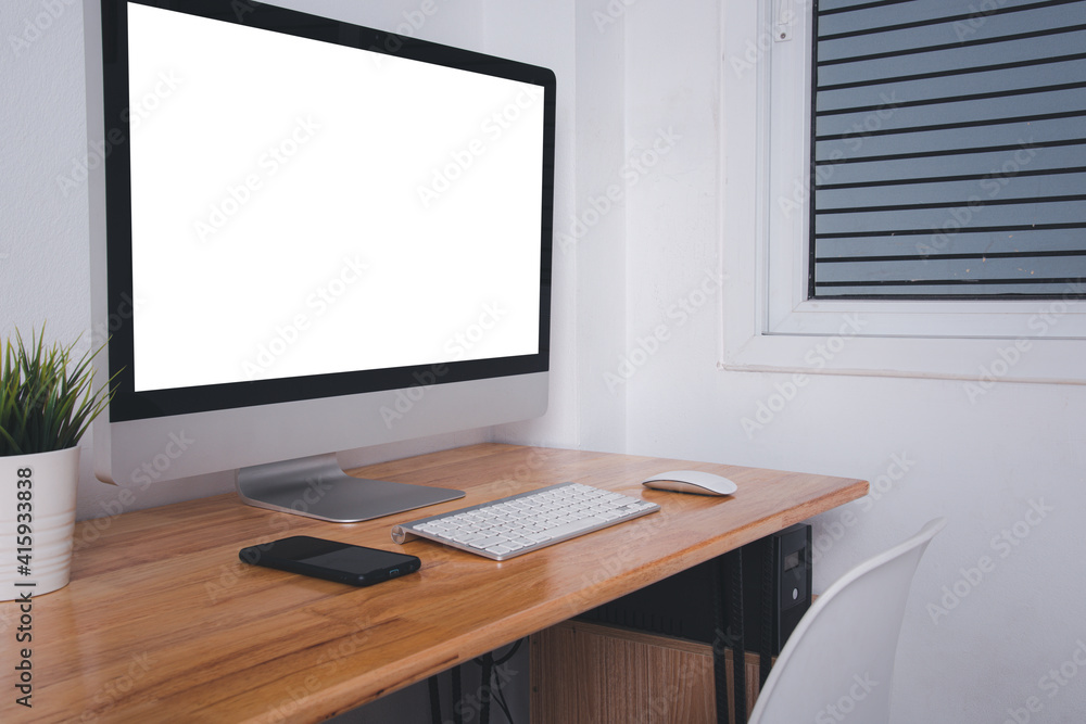Poster computer monitor with white blank screen on the business desk with wireless mouse, keyboard at home 