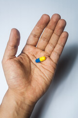 capsule on palm of hand, general view