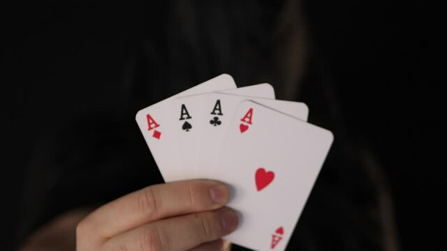 Mysterious anonymous card player holds four aces in hand