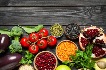 Different vegetables, seeds and fruits on black wooden table, flat lay with space for text. Healthy diet