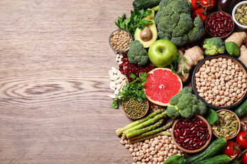Fresh vegetables, fruits and seeds on wooden table, flat lay. Space for text