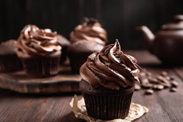 Delicious cupcake decorated with cream on wooden table, closeup