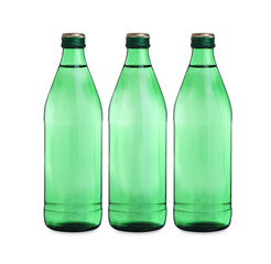 Glass bottles with water on table against white background