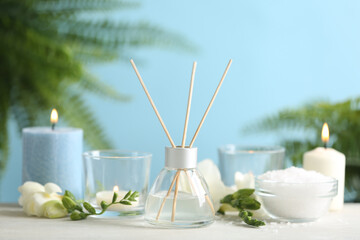 Beautiful spa composition with reed diffuser and candles on white table