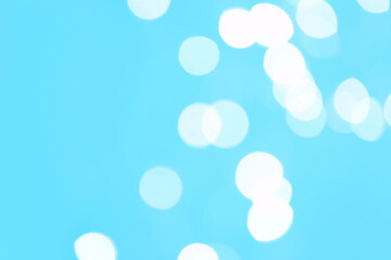 Beautiful blurred lights on cyan background, bokeh effect