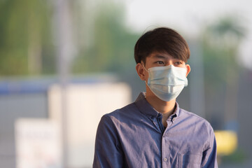 Asian man wear face mask protect coronavirus covid 19 standing outdoor street urban