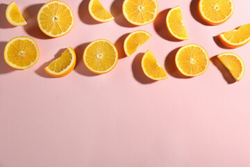 Cut fresh ripe oranges on pink background, flat lay. Space for text