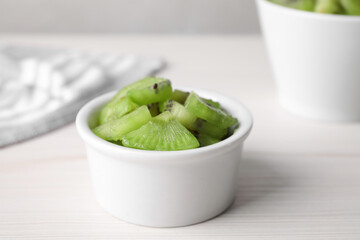 Bowl with kiwi slices on white table