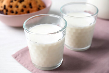 Glasses of delicious milk on light table