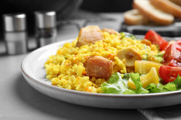 Delicious pilaf with chicken meat on light grey table, closeup
