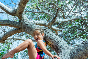Fototapeta premium Menina pensativa em cima de uma árvore