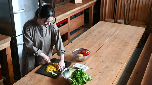 キッチンで野菜の下ごしらえや料理をする美しい日本人女性の動画