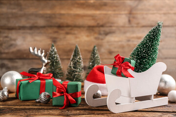 Beautiful Christmas composition with miniature sleigh on wooden table