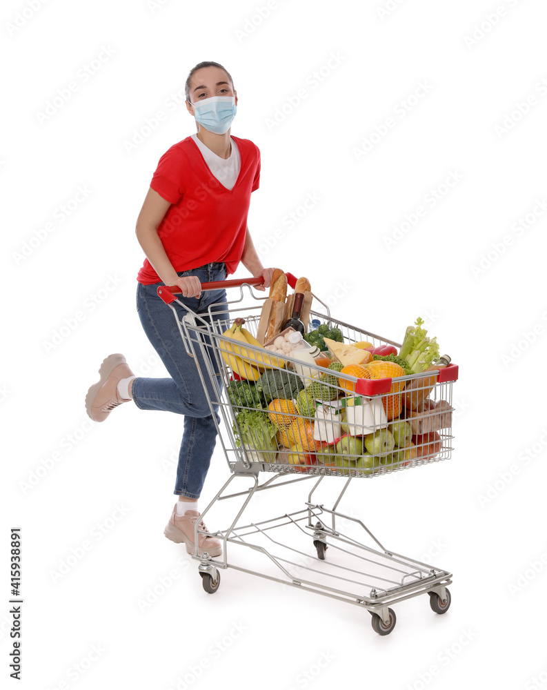 Poster Woman with protective mask and shopping cart full of groceries on white background