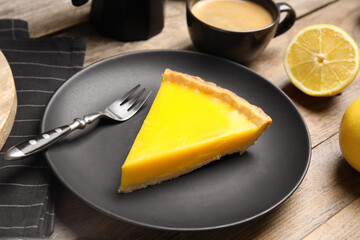 Slice of delicious homemade lemon pie on wooden table