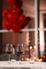 Fototapeta na wymiar Glasses of wine for romantic dinner on table in restaurant
