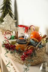 Wicker basket with gift set and Christmas decor on shelf