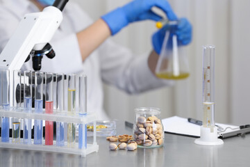 Fototapeta premium Pistachios on table and scientist proceeding quality control in laboratory