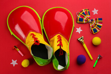 Flat lay composition with clown's accessories on red background