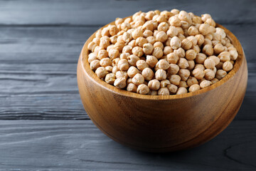 Raw chickpeas on black wooden table, closeup