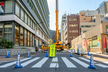 工事現場でアウトリガー使用中のクレーン車
