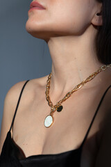 Beautiful model brunette in modern gold metal necklace chain