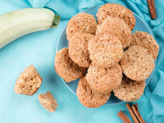 Close up view of muffin with zucchini, carrots, apple and cinnamon on blue concrete background. Sweet vegetables homemade muffins. Toddler-friendly recipe idea.. Top view or flat-lay.