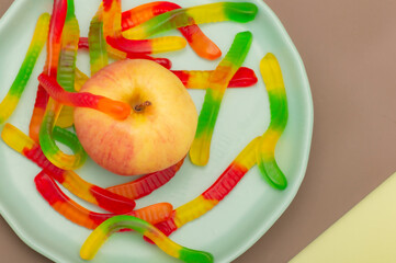 apple on a plate with gummy worms