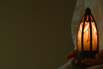  “art deco” lamp. made in France.
Asian woman holding candle shines with warm light . 


dim lighting room soft focus image.