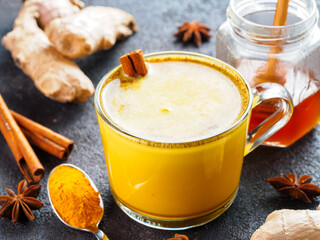 Healthy drink golden turmeric latte in glass cup.Gold milk with turmeric,ginger root,cinnamon...