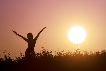 Happy woman open arms with sun background
